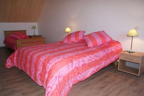 a bedroom with a pink bed and two night stands at Gîte Binnert Bader in Nothalten