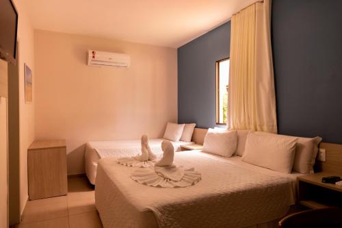 a hotel room with two beds and a window at Pousada Mariluz in Maragogi