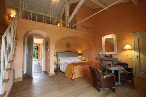 a bedroom with a large bed and a staircase at L'Andana Tenuta La Badiola in Castiglione della Pescaia