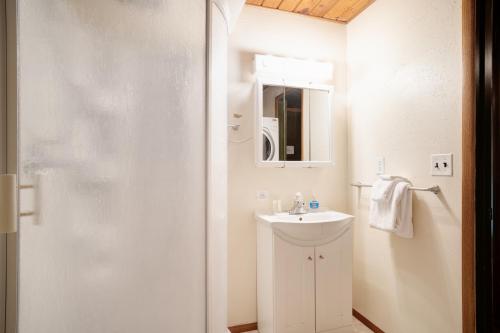 a white bathroom with a sink and a mirror at Cedarwood Grove in Baring