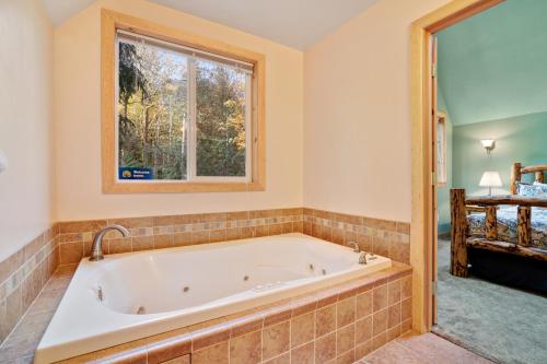 Baring的住宿－Cedarwood Grove，带浴缸的浴室和窗户