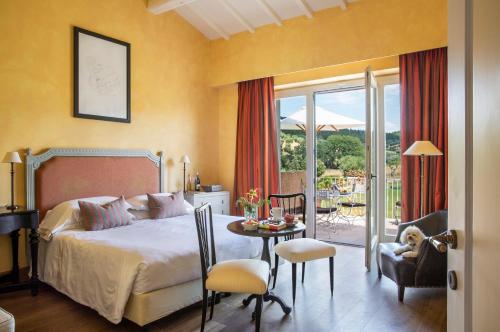 a bedroom with a bed and a table and chairs at L'Andana Tenuta La Badiola in Castiglione della Pescaia