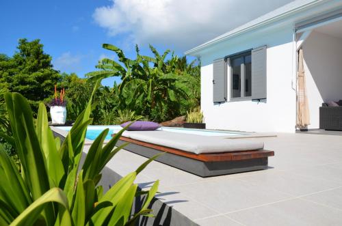 a bed on the patio of a villa at Villa Coco Cannelle in Deshaies