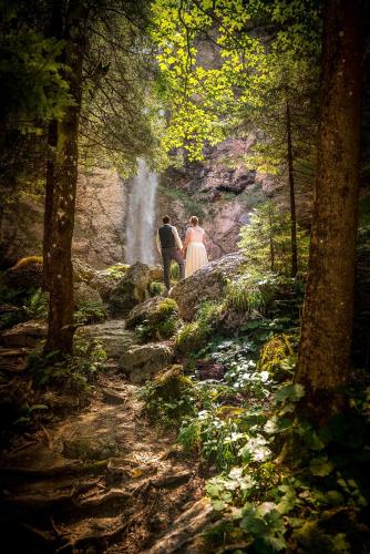 a man and a woman walking down a path near a waterfall at Waldgasthaus Lehmen in Weissbad