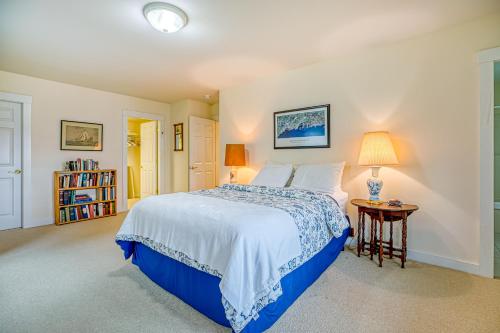 a bedroom with a blue and white bed and a table at Compass Rose in Seal Cove