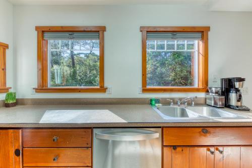 a kitchen with a sink and two windows at Cozy Cottage in Florence
