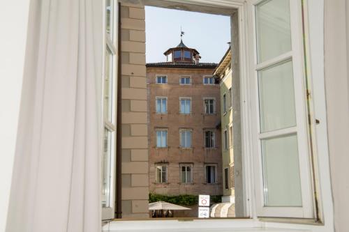 an open window with a view of a building at YUGOGO MAZZINI 41 Trento Centro in Trento