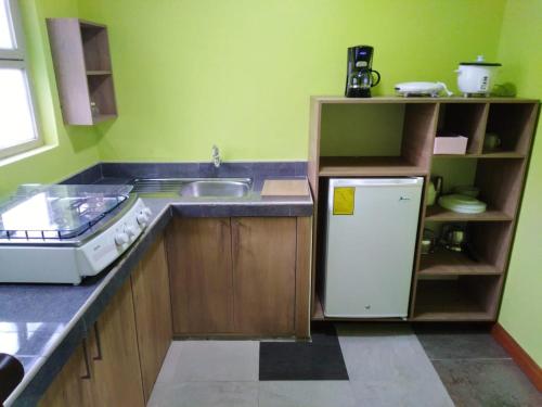 a kitchen with a sink and a refrigerator at HOSPEDAJE CARIGAN in Loja