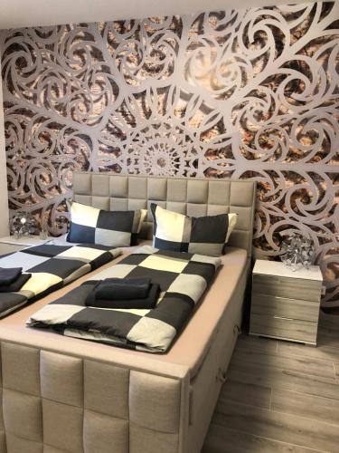 ein Schlafzimmer mit einem großen Bett vor einer Wand in der Unterkunft Ermmes Ferienwohnungen in Sinsheim