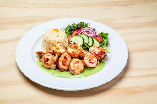 a plate of food with shrimp and vegetables on a table at Hotel Maioris Kumate Culiacán in Culiacán