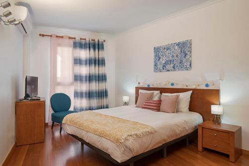 una camera da letto con un letto e una sedia blu di Apartamento Lobo Marinho by An Island Apart a Santa Cruz