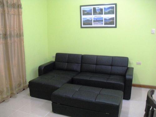 a living room with a black couch in a room at Piarco Village Suites in Piarco
