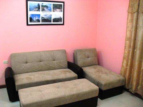 a living room with a couch and a ottoman at Piarco Village Suites in Piarco