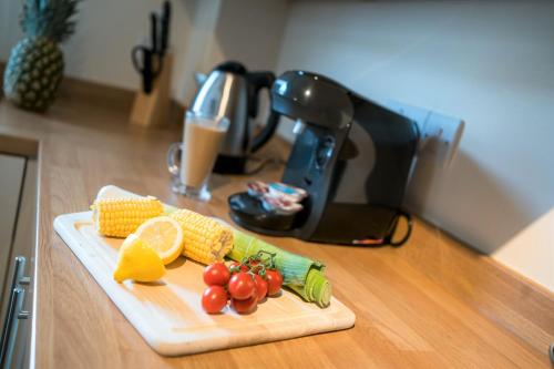a cutting board with corn and vegetables on a counter at Church View Irene Court Cockermouth in Cockermouth