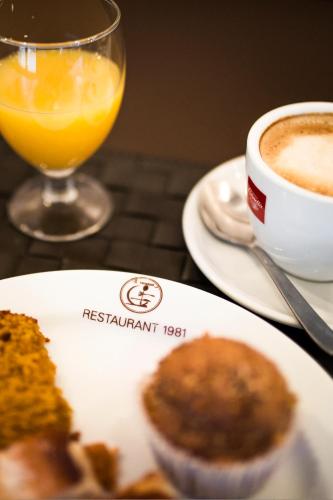 une table avec une assiette de nourriture et une tasse de café dans l'établissement La Trobada Hotel Boutique, à Ripoll