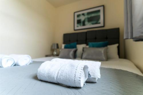 a pile of towels sitting on top of a bed at Church View Irene Court Cockermouth in Cockermouth