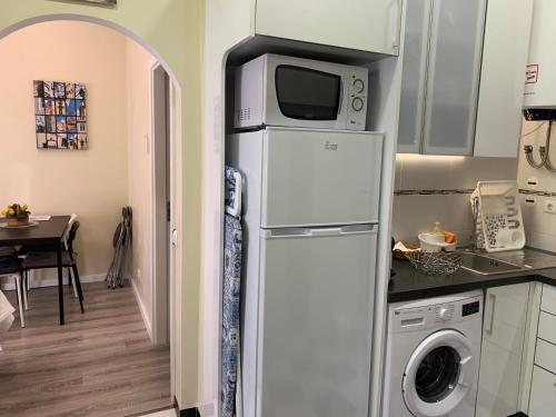 a refrigerator with a microwave on top of it in a kitchen at Excellent 2 bedroom apartment in Lisbon in Lisbon