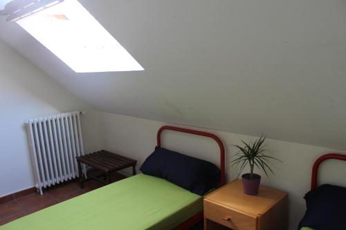 a small bedroom with two beds and a skylight at Albergue de Canfranc Estación in Canfranc-Estación