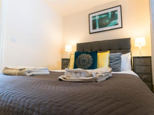 ein Schlafzimmer mit einem großen Bett mit Handtüchern darauf in der Unterkunft Wordsworth Apartment Irene court in Cockermouth