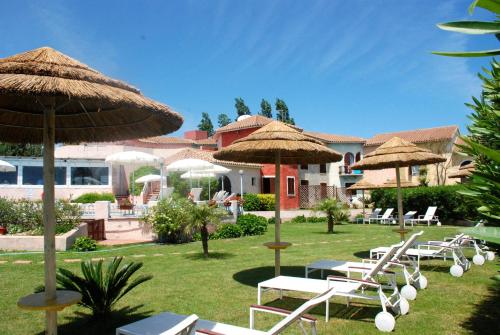 a group of chairs and umbrellas in a yard at Hotel Stefania Boutique Hotel by the Beach in Olbia