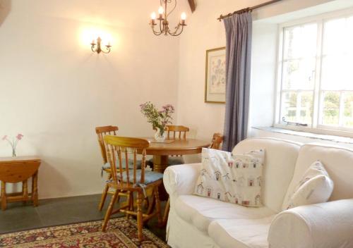 a living room with a white couch and a table at Old Newham Farm in Camelford