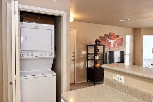 a kitchen with a washer and dryer next to a counter at Riverside Retreat in New Braunfels