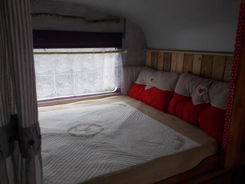 ein kleines Bett in einem kleinen Zimmer mit Fenster in der Unterkunft le clos des epinettes in Angé