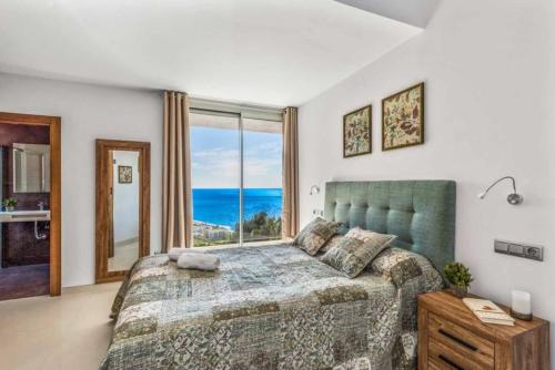 a bedroom with a bed and a large window at Villa Tierra in Nerja