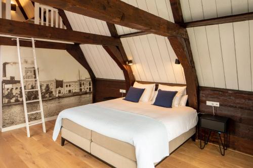 a bedroom with a large white bed with blue pillows at Saenliefde in Wormer