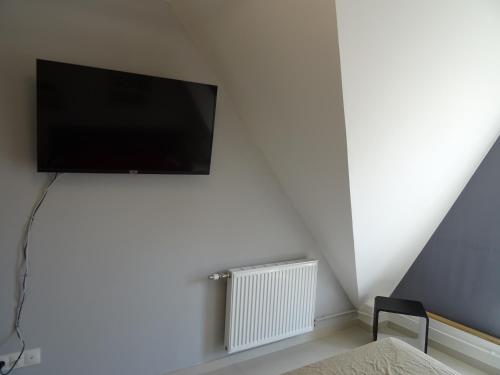 a flat screen tv on a wall in a room at Appartement L'Entonnoir in Berck-sur-Mer