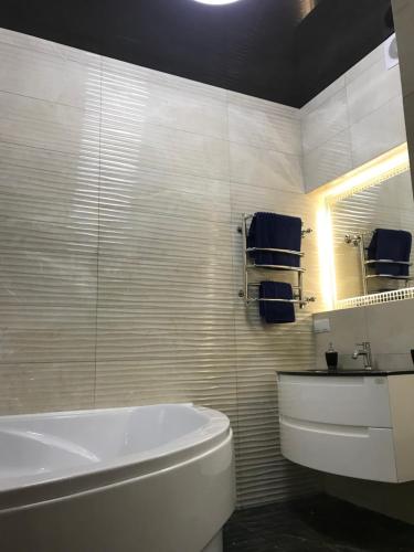 a bathroom with a tub and a toilet and a sink at New luxury Apartment in the Center on Konstitution Square in Kharkiv