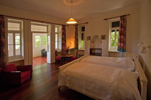 a bedroom with a bed and a living room at Quinta das Colmeias in Santo António da Serra