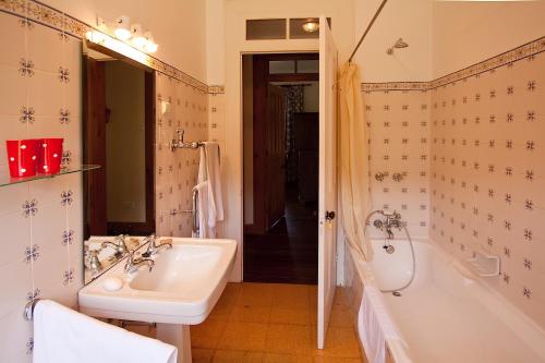 y baño con bañera, lavamanos y bañera. en Quinta das Colmeias, en Santo da Serra