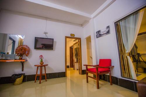 a room with a red chair and a door at Moloppor Villa in Battambang