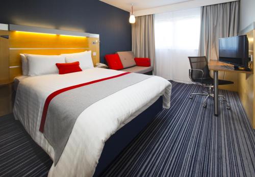 a hotel room with a large bed and a television at Holiday Inn Express London - Epsom Downs by IHG in Epsom