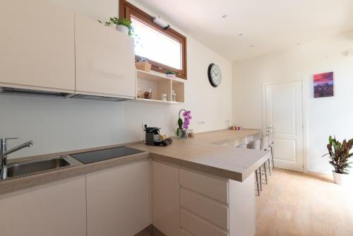 uma cozinha com armários brancos, um lavatório e uma janela em FLOREST Guest House em Florença