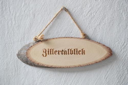 a wooden sign hanging on a wall at Kama Alm in Aschau