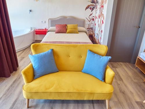 Sofá amarillo en una habitación con cama en Morada 2, en Casas del Cerro