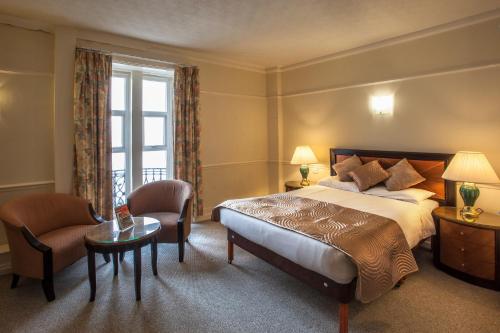 A bed or beds in a room at The Metropole Hotel