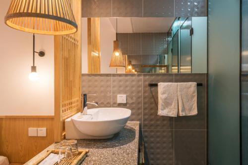 a bathroom with a white sink and a mirror at Zen Tea House Seven Stars Park in Guilin