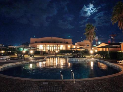 a large pool in front of a building at night at Hotel Minerva in Brindisi