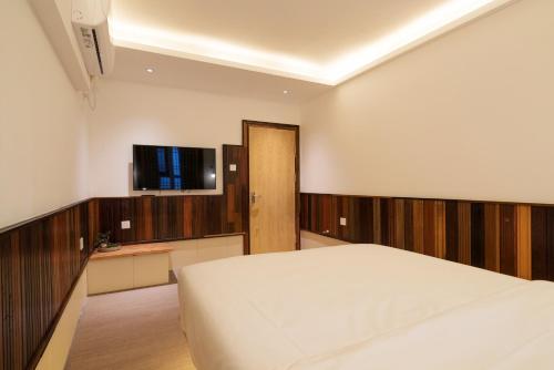 a bedroom with a bed and a flat screen tv at Zen Tea House Seven Stars Park in Guilin