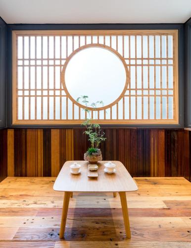 a table with a potted plant on it in front of a window at Zen Tea House Seven Stars Park in Guilin