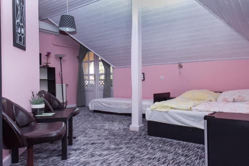 バラトンケレストゥールにあるFamilia Apartman 304のピンクの壁のベッドルーム1室(ベッド2台付)