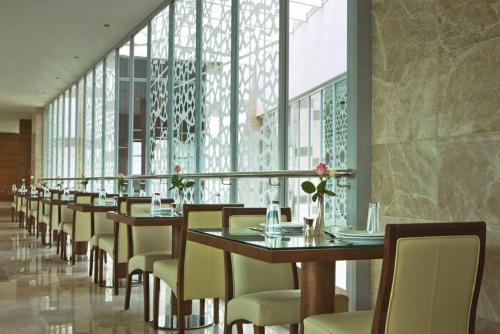 a row of tables and chairs in a restaurant at Karbala Rayhaan Hotel & Suites in Karbalāʼ