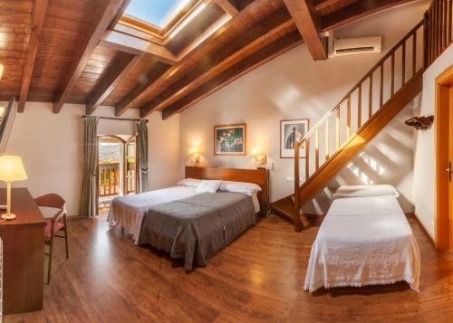 a bedroom with two beds and a staircase at Hotel Fonda Merce in Llivia