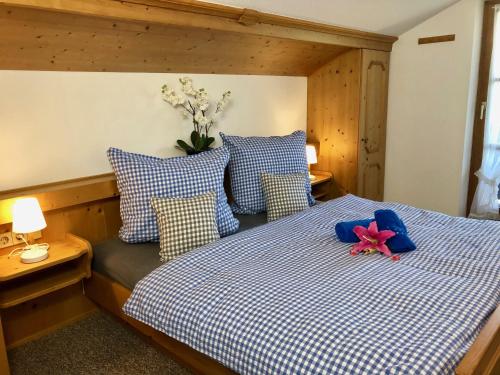 貝希特斯加登的住宿－FeWo Bergglück，卧室配有蓝色和白色的床,上面有粉红色的花朵