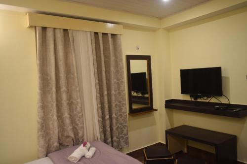 a hotel room with a bed and a television at Denzong Khim in Gangtok