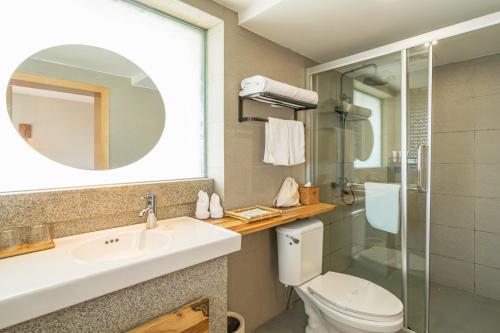 a bathroom with a sink and a toilet and a mirror at Zen Tea House Seven Stars Park in Guilin
