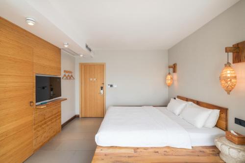 a bedroom with a large white bed and a tv at Zen Tea House Seven Stars Park in Guilin
